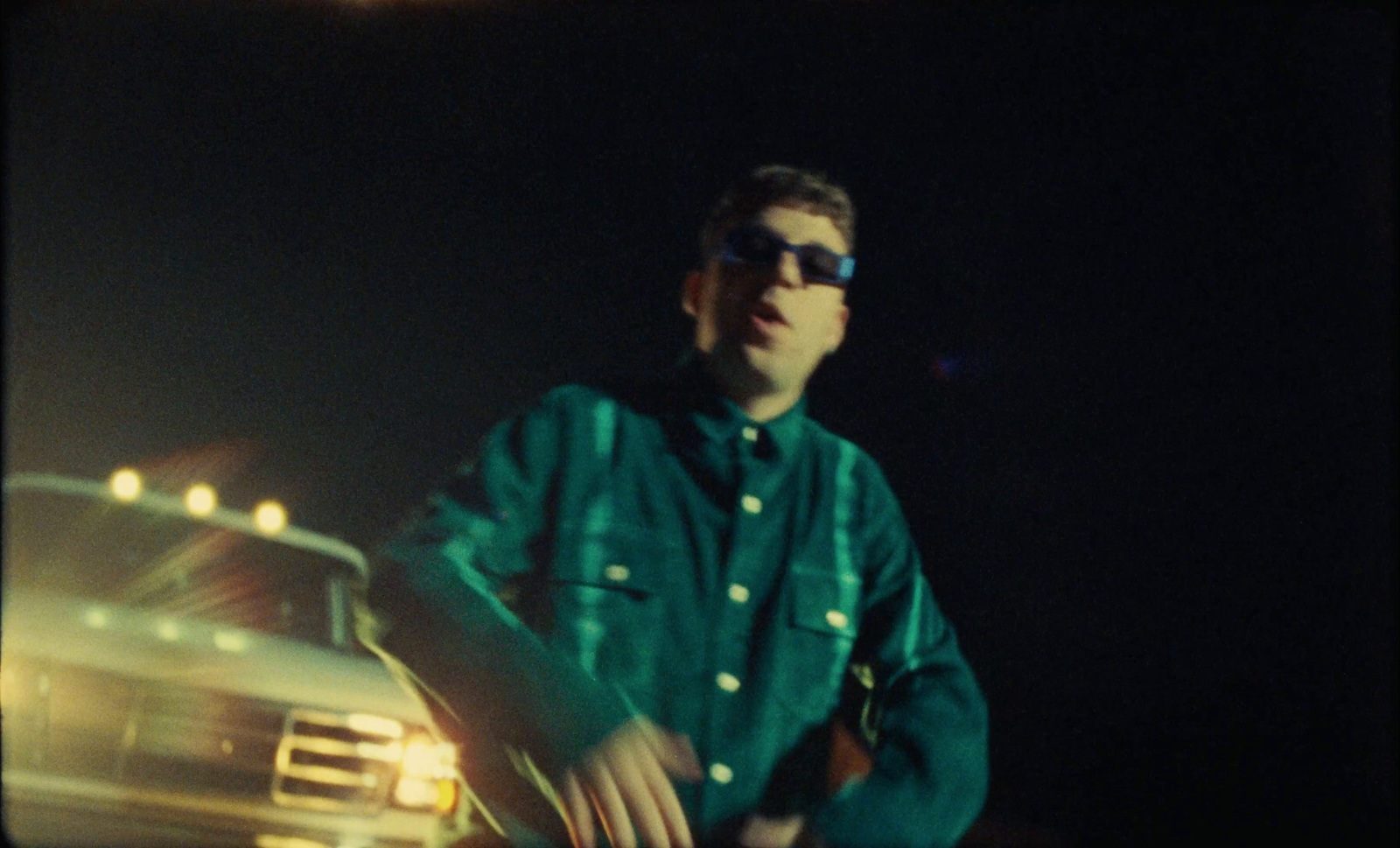 a man wearing sunglasses standing next to a truck