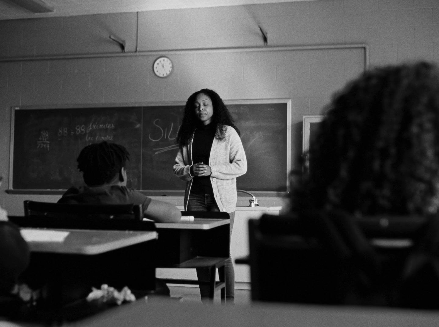 a woman standing in front of a classroom full of students