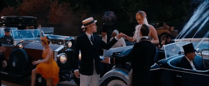 a group of people standing around a vintage car