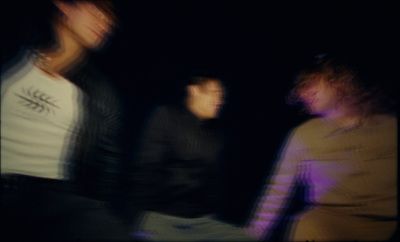 a blurry photo of three people in a dark room