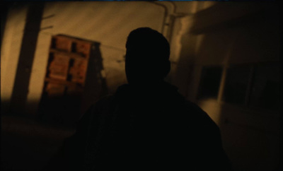 a man standing in a dark room with his back to the camera