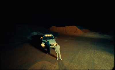 a person standing next to a car in the dark