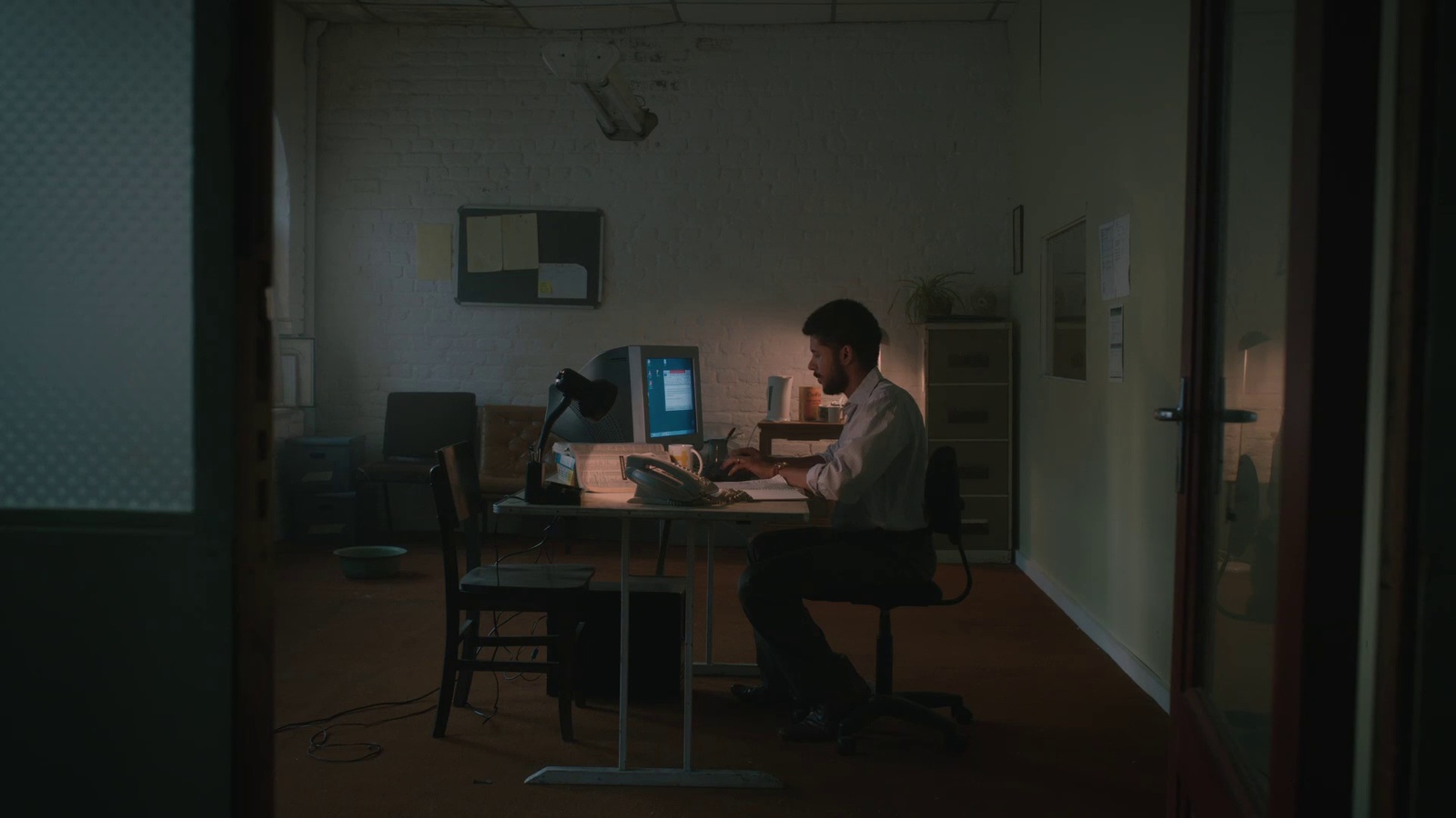 a man sitting at a desk in front of a computer