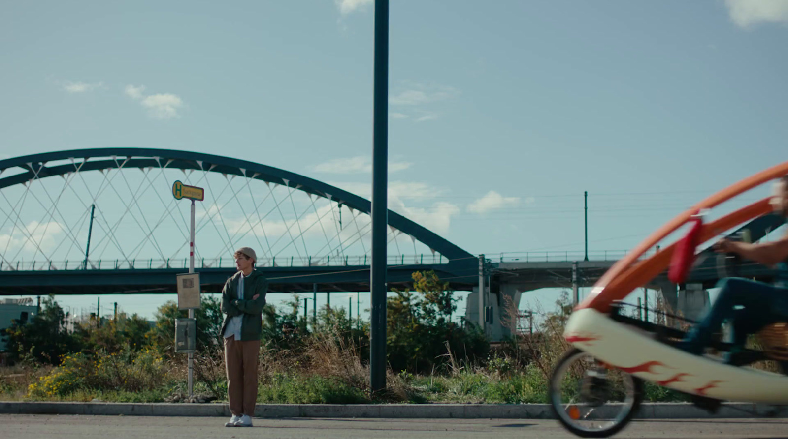 a woman standing on the side of a road next to a motorcycle