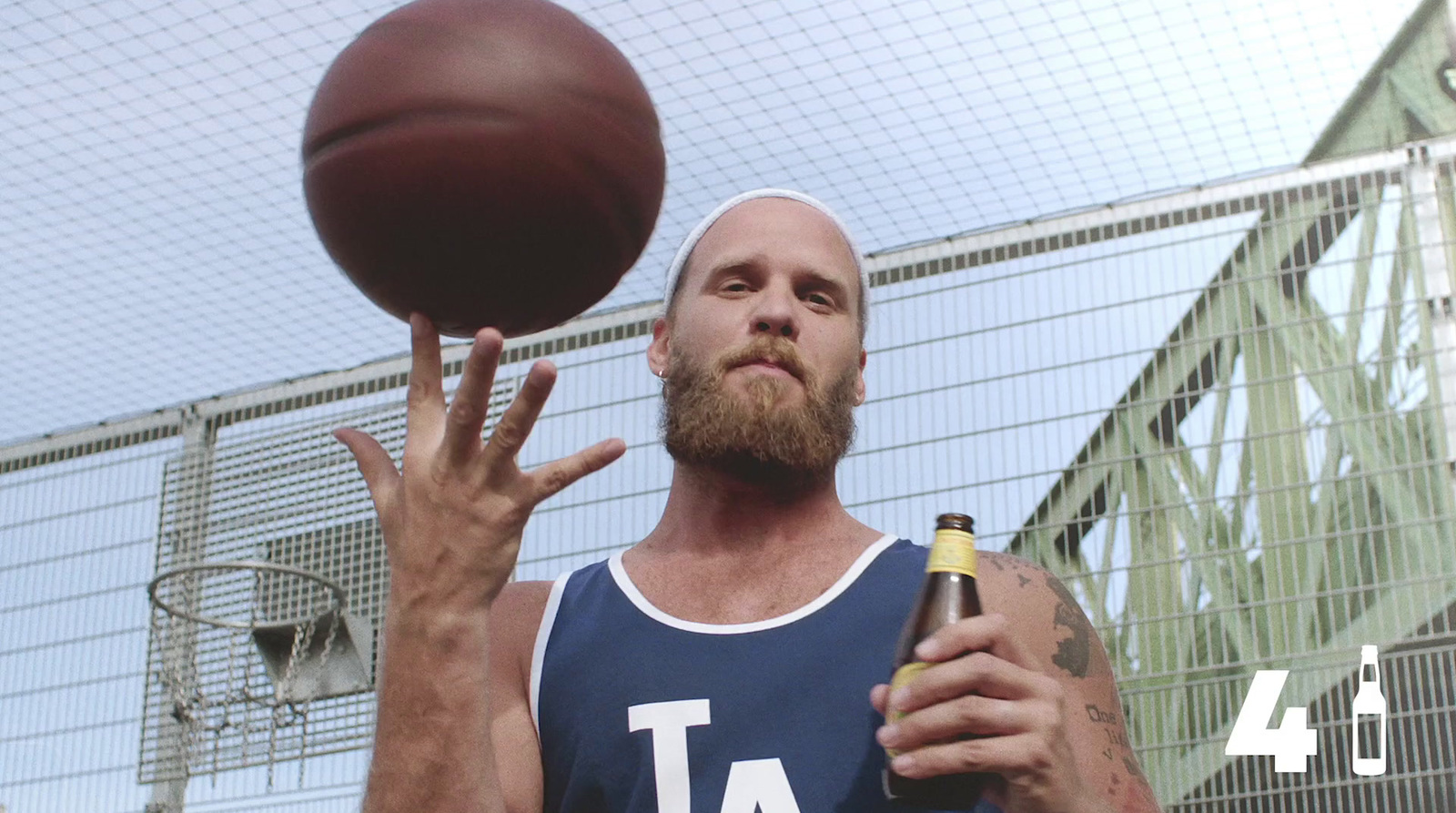 a man holding a beer next to a basketball