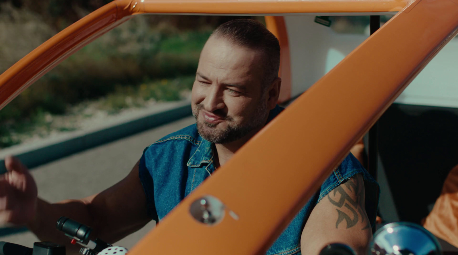 a man in a blue shirt driving a motorcycle