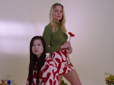 a woman sitting on the back of a woman holding a flower