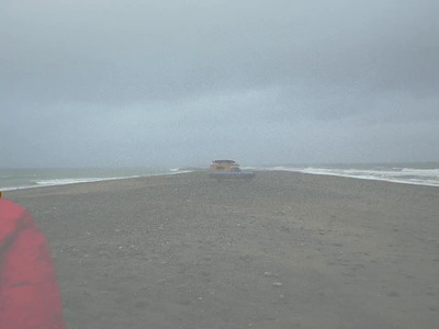 a person in a red jacket standing on a beach