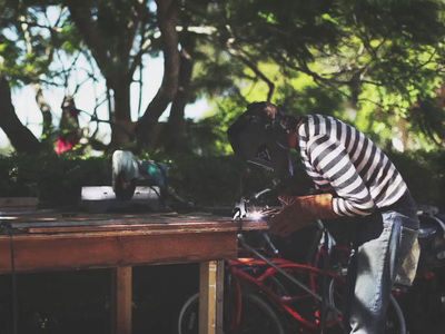 a man in striped shirt standing next to a red bike