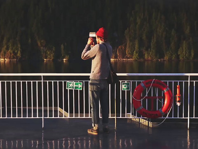 a man standing on a pier with a cell phone to his ear