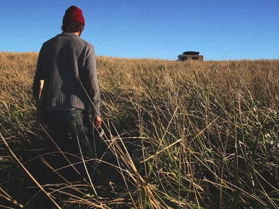 a person standing in a field of tall grass