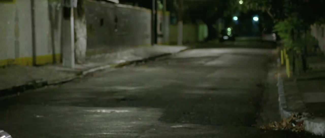 a man riding a skateboard down a street at night