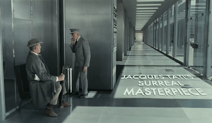 a couple of men standing next to each other in a hallway