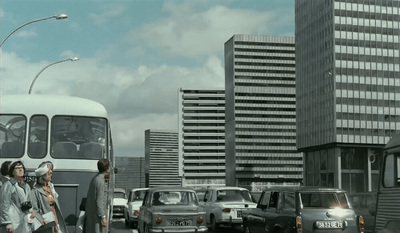 a group of people walking down a street next to a bus