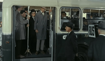 a group of men standing next to each other in front of a bus