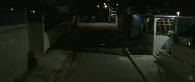 a dark alley at night with street lights on