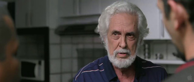 a man with white hair and a beard talking to another man
