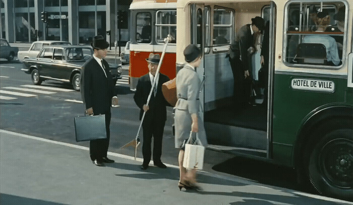 a group of men standing next to a bus