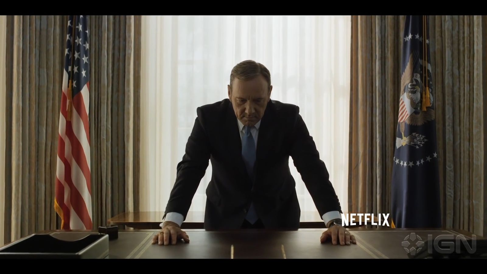 a man in a suit and tie standing at a table