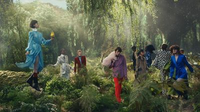 a group of people walking through a lush green forest