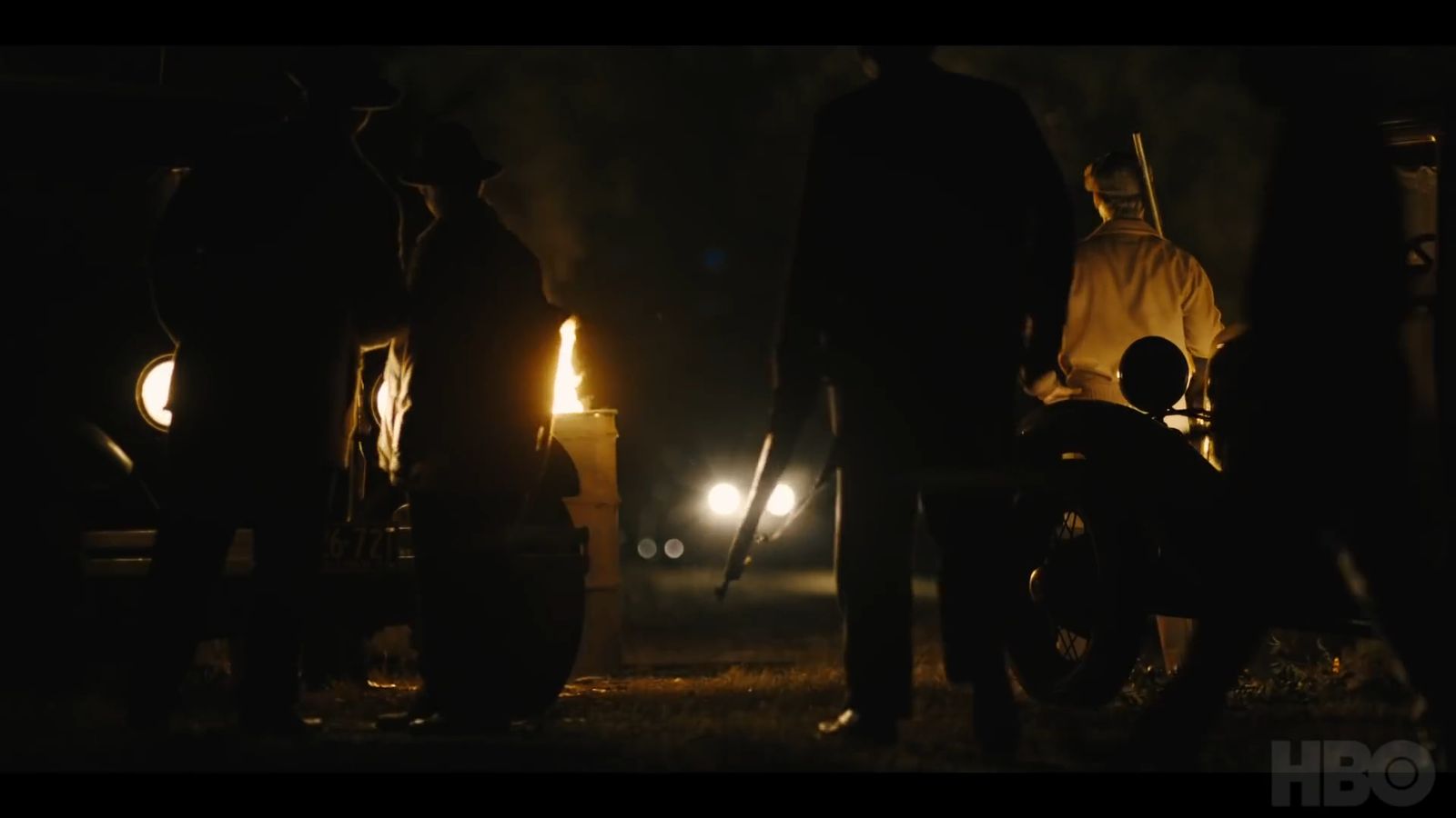 a group of people standing around a motorcycle at night