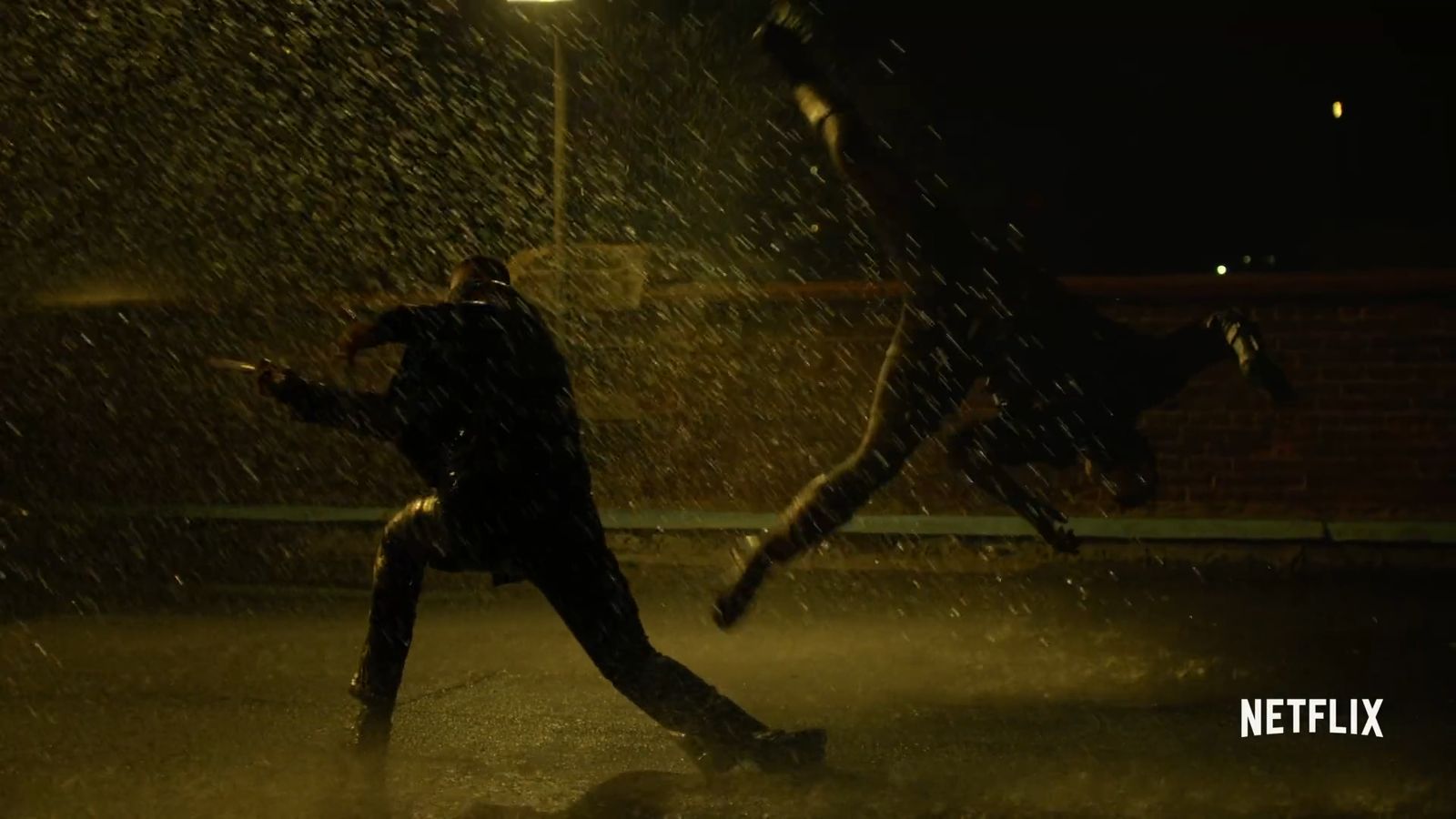 two people running in the rain at night