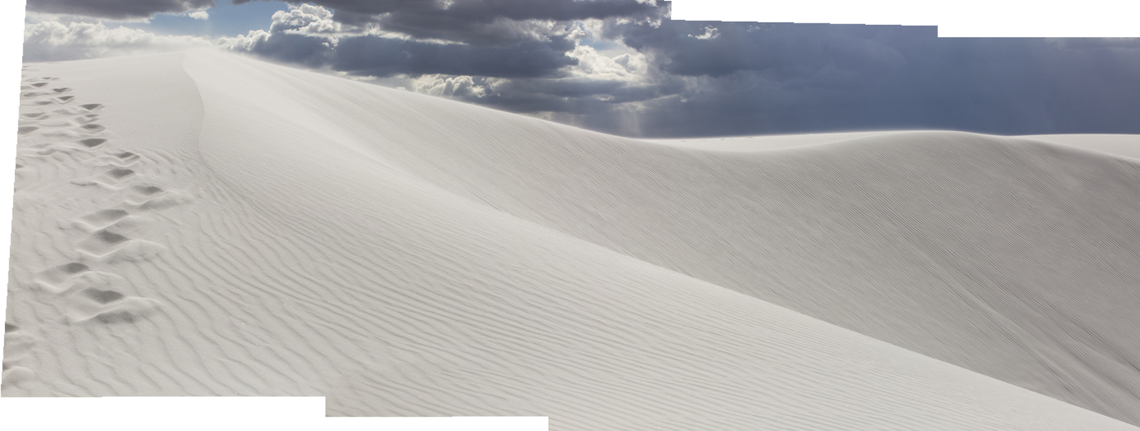 a white sand dune with footprints in the sand