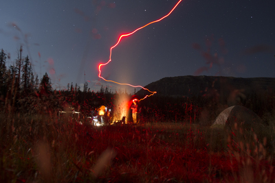 a couple of people standing in a field at night