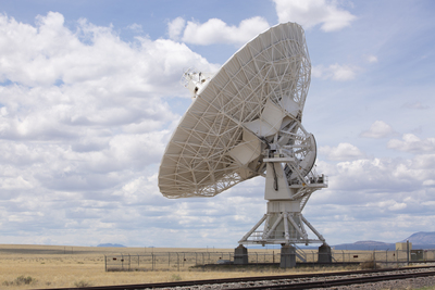 a large satellite dish sitting on top of a train track