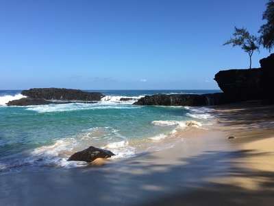 a sandy beach with waves coming in to shore