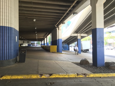 a man walking down a sidewalk next to a blue and white building