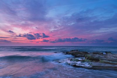 a beautiful sunset over the ocean with waves