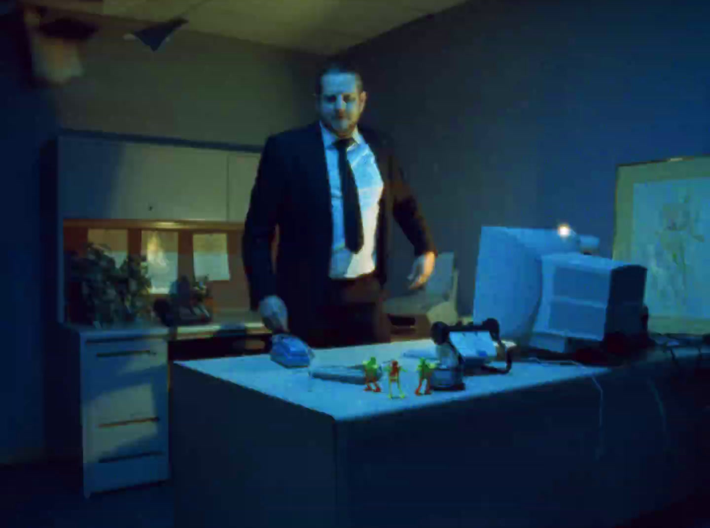 a man in a suit and tie standing next to a desk