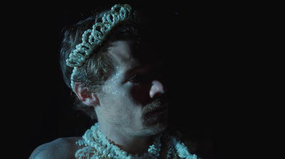 a man wearing a crochet headband in the dark