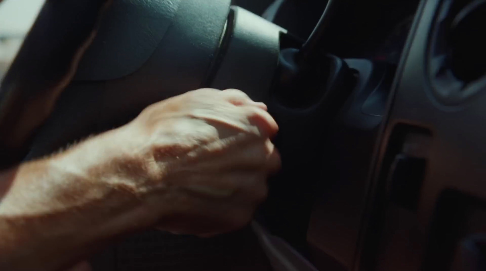 a person holding the steering wheel of a car