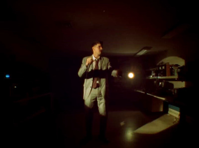 a man in a suit standing in a dark room