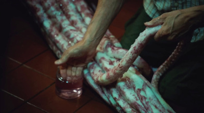 a person holding a glass filled with blood