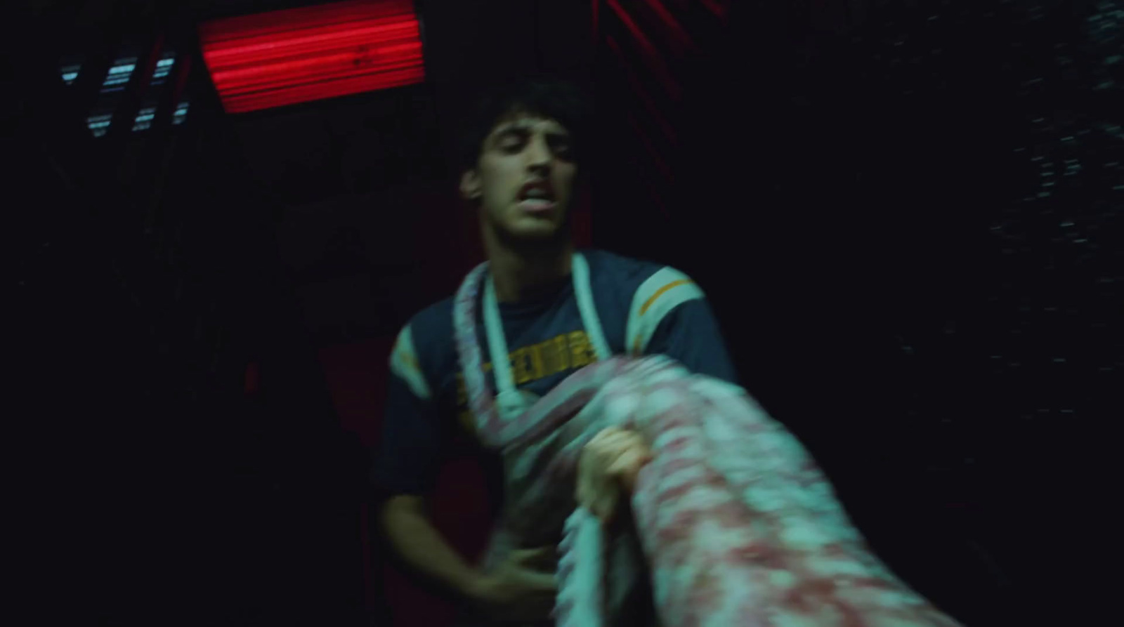 a man holding a large piece of meat in a dark room