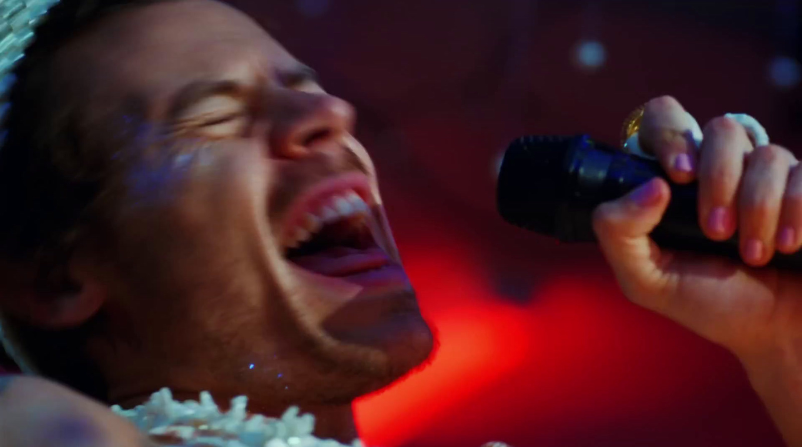 a man singing into a microphone on stage