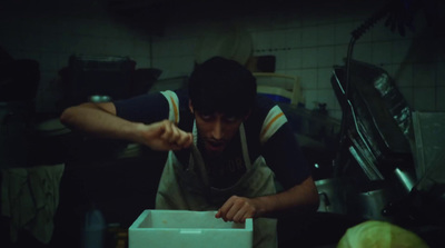 a man standing over a box in a kitchen