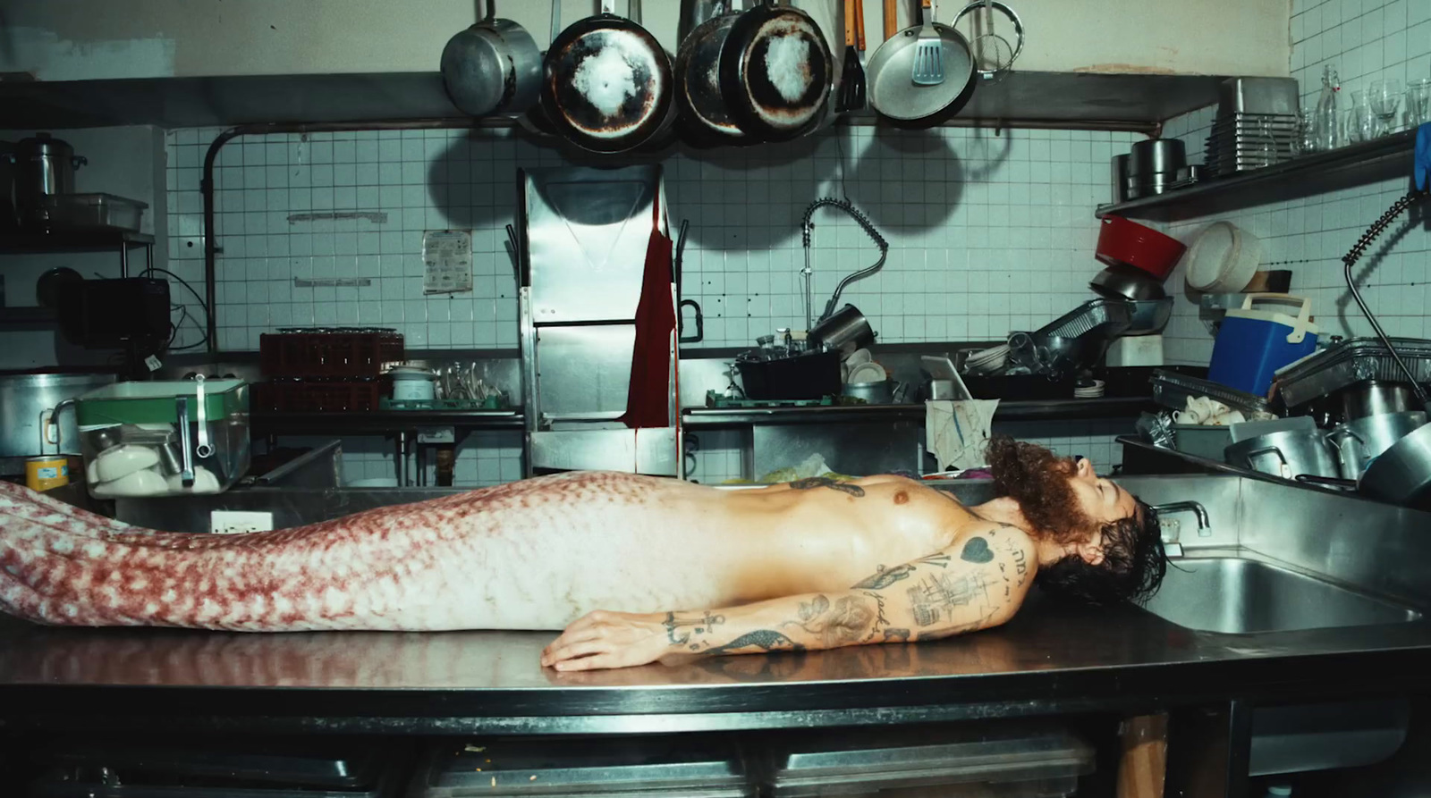 a man laying on a counter in a kitchen