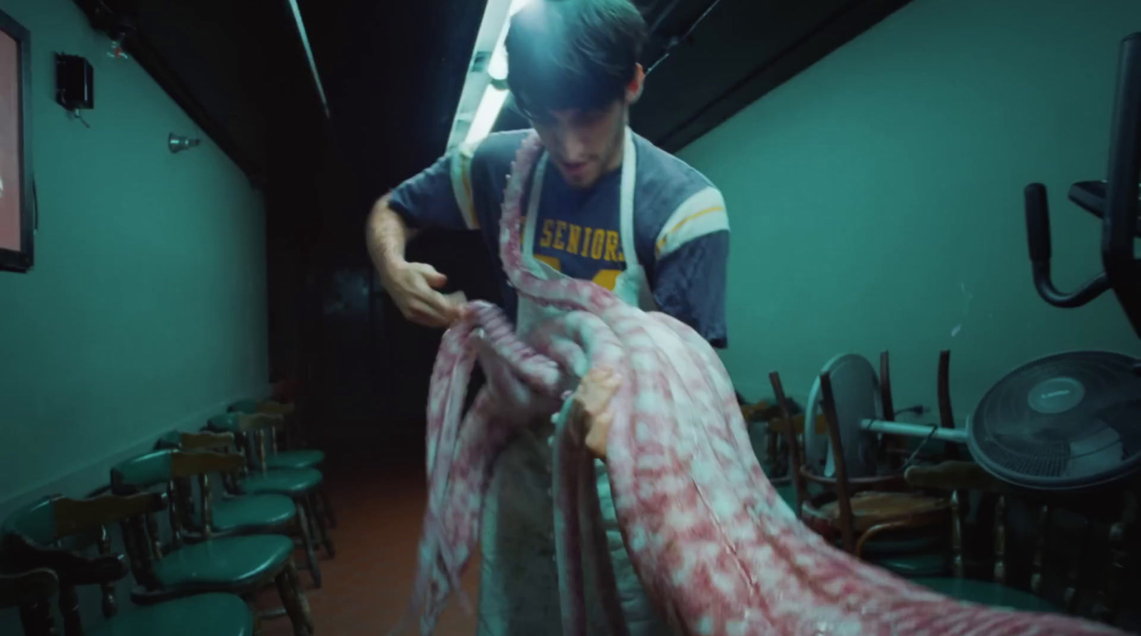 a man holding a large piece of meat in a room