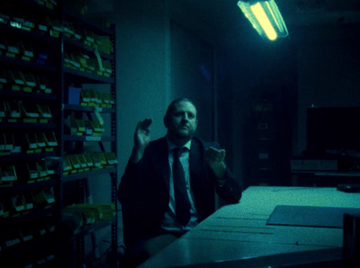 a man sitting at a desk in a dark room