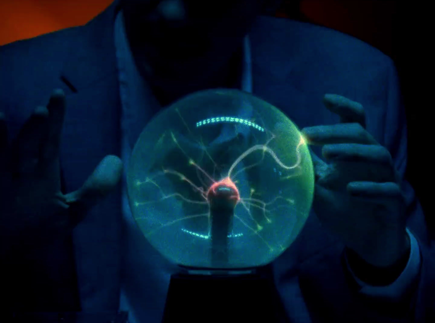 a man in a suit holding a glass ball in his hands