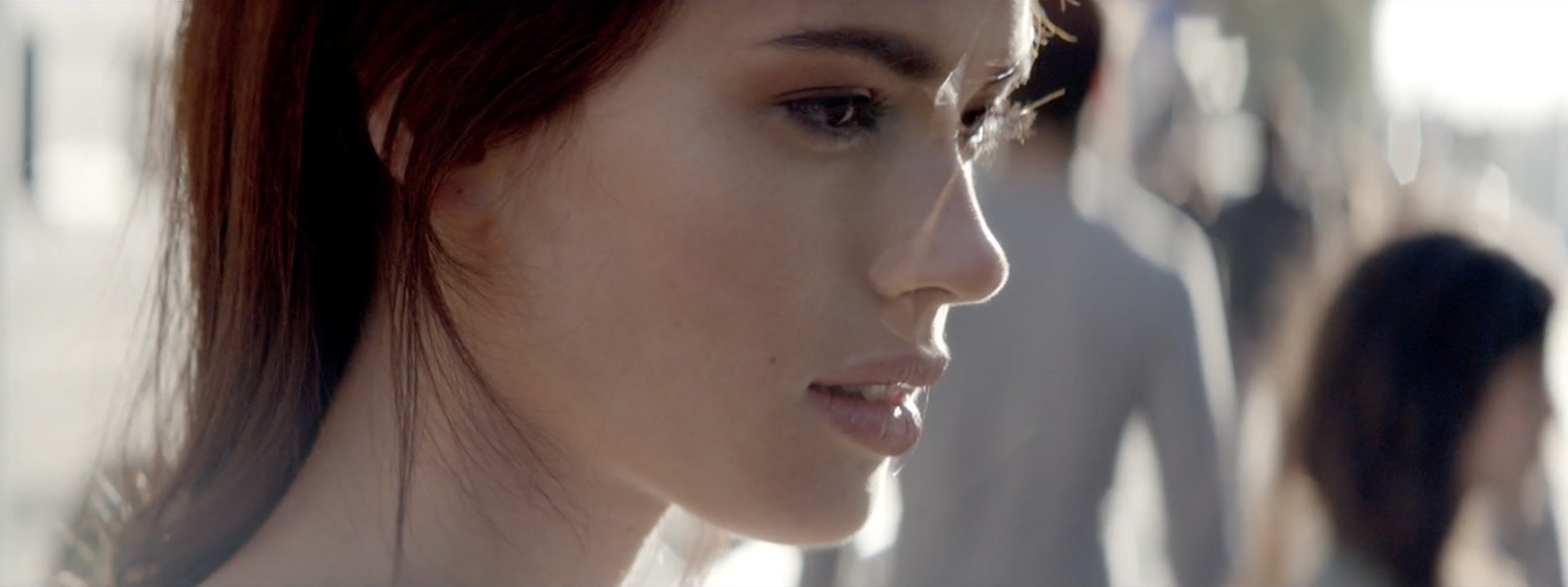 a close up of a woman's face with other women in the background