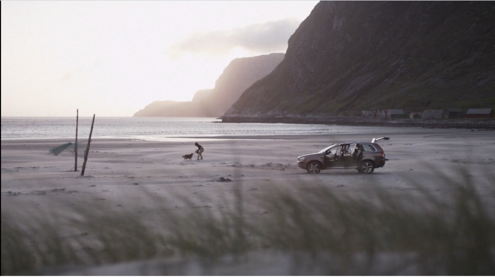 a car parked on a beach next to the ocean