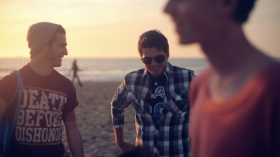 a group of young men standing next to each other on a beach