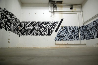 a white room with black and white graffiti on the walls