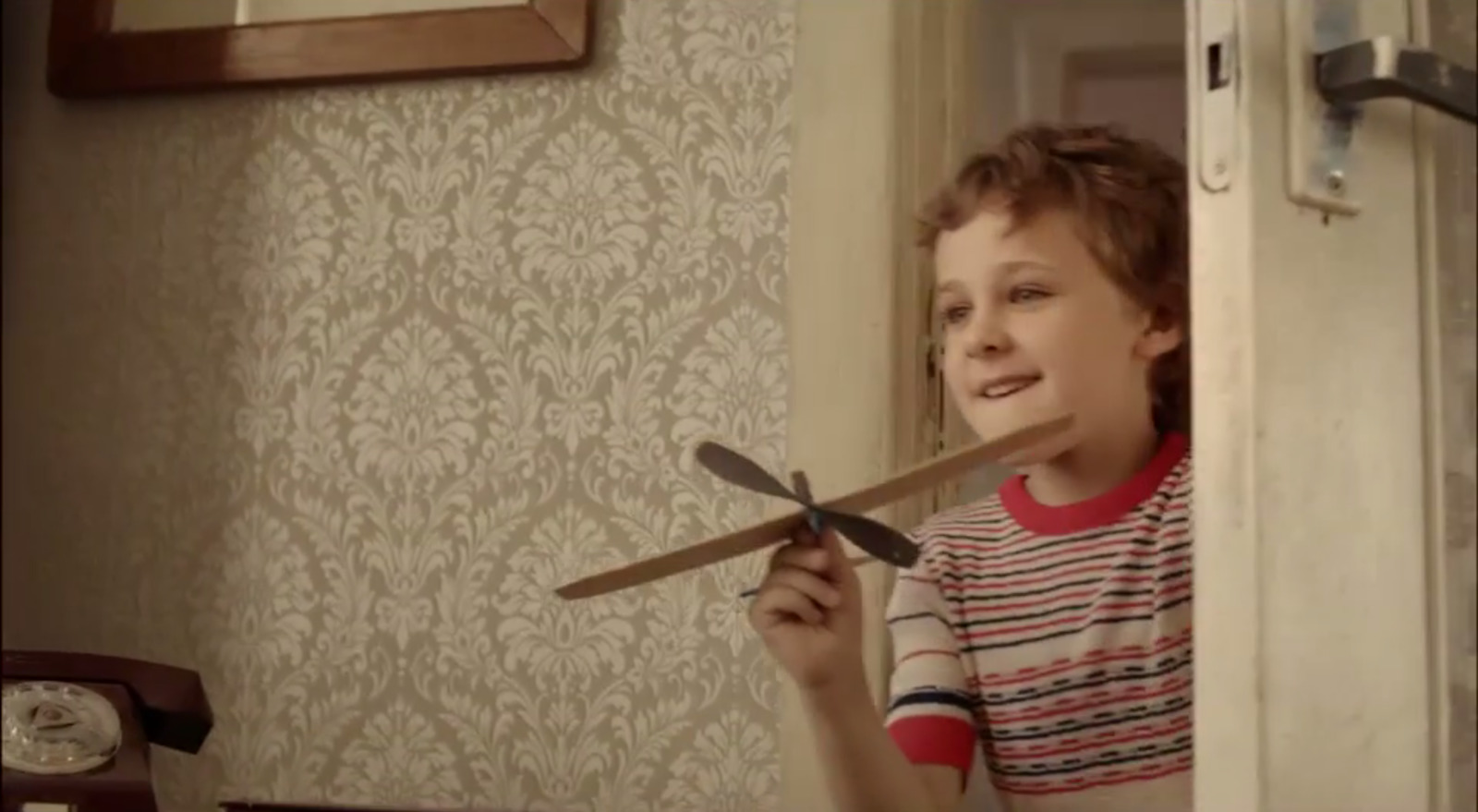 a young boy holding a pair of scissors in his hand