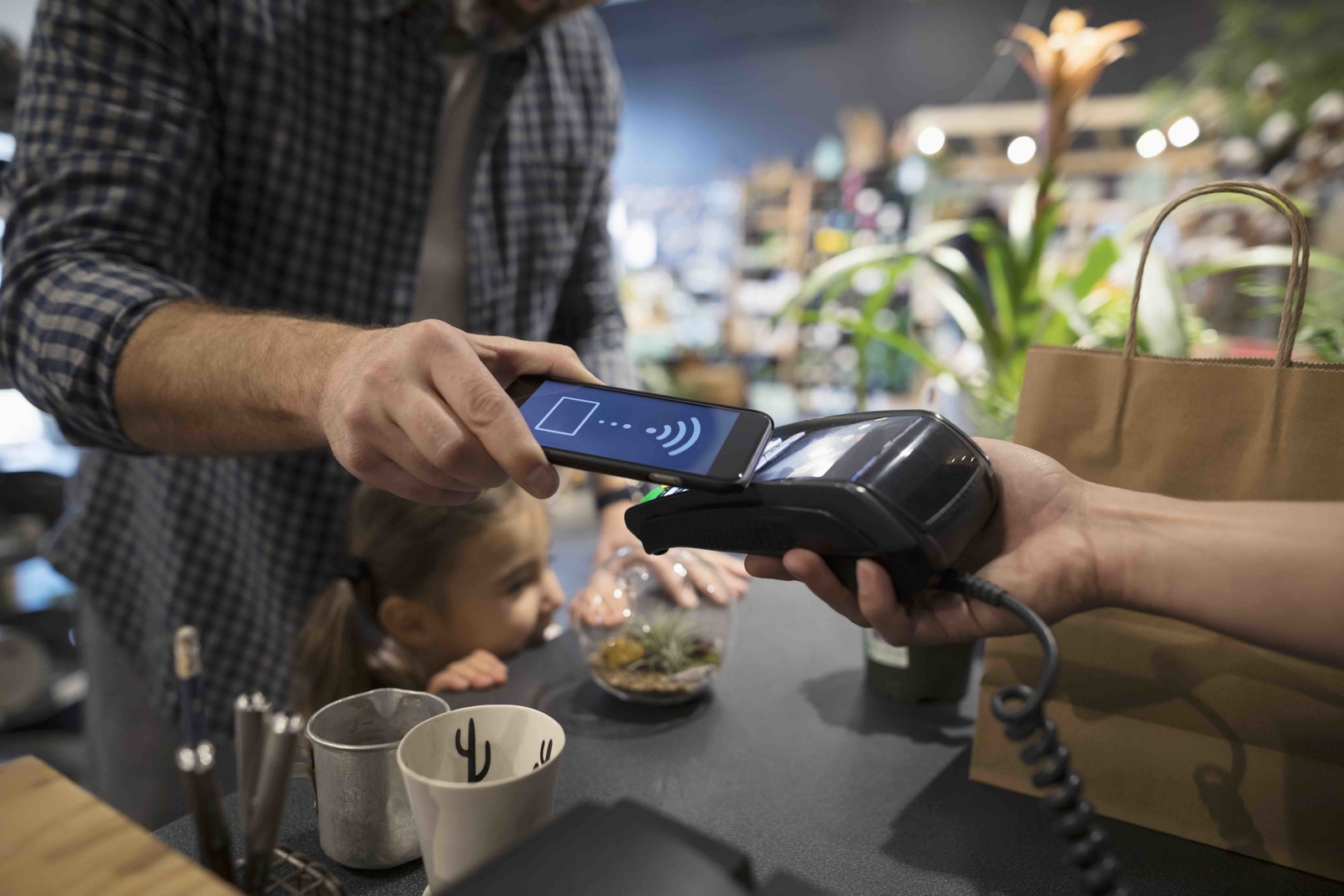 a man is paying a woman with a cell phone